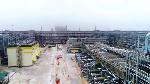 High-tech gasoline and fuel plant with pipelines on foggy day. Drone footage.