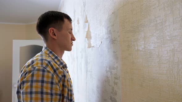 Emotional Guy in Shirt Tears Old Wallpapers Into Pieces