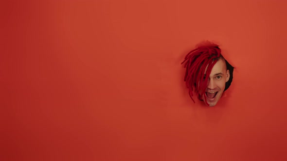 Smiling Man with Red Dreadlocks in Hole in Wall