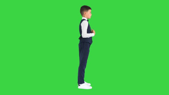 Little Boy in a Bow Tie and Waistcoat Talking on a Green Screen Chroma Key