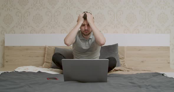 Businessman Holding His Head and He Looks at the Laptop with a Very Sad Face