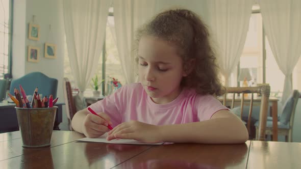 Cute Primary Child School Child of 78 Years Old at Home Relaxing Sits in House and Paints on Paper