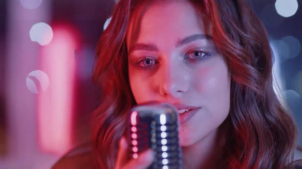 Portrait of a Young Female Singing in a Nightclub Party Closeup of a Woman's Face in Neon Light