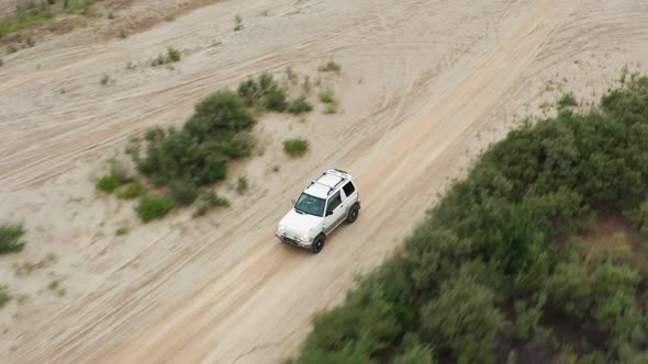 Aerial View of a Car Driving on Sand