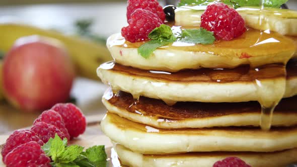 Pouring Honey on Stack of Pancakes