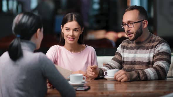Male and Female Discussing Business at Meeting in Cafeteria