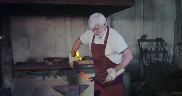 Blacksmith Hot Metalwork with Tongs Holding