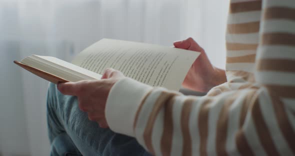 Closeup of Woman Reading a Book in Cozy Living Room