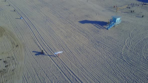 Aerial drone uav view of a surfer walking with his sup surfboard.