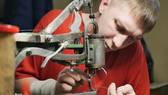 Master Repairing Shoes Insert Thread Into the Needle of a Sewing Machine