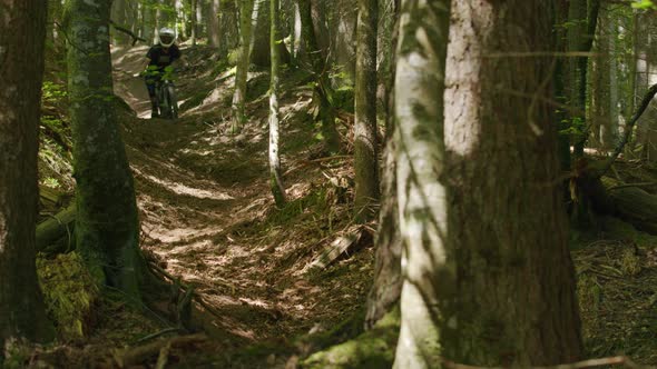 Mountain biker carves down a dusty gully and kicks up dust
