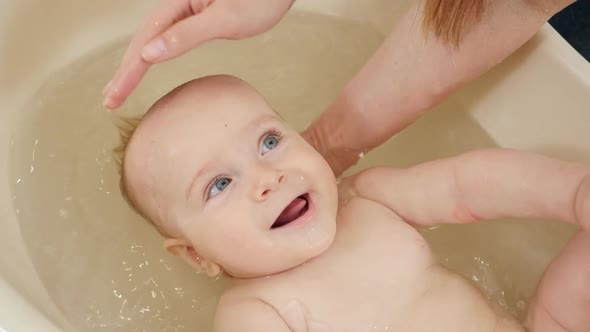 Portrait of Smiling Cute Baby Boy Enjoying Washing and Swimming in Bath