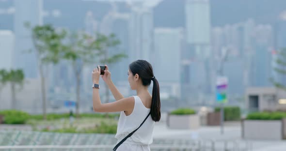 Woman take photo on cellphone in city of Hong Kong