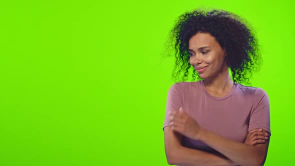 Black Female Has Broad Smile Indicates Aside at Blank Space Over Chroma Key