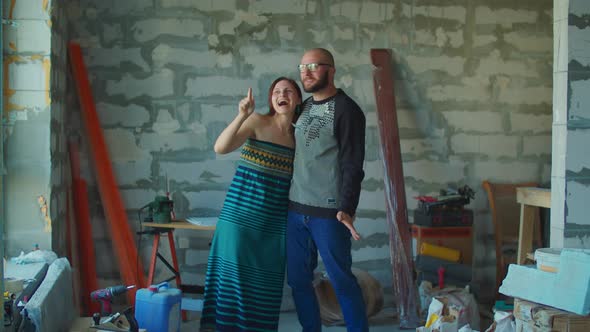 Young couple is happy with new apartments, Man and woman hugging at construction site 