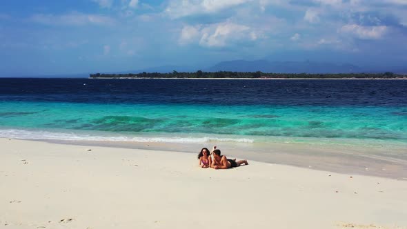 Happy lady and man on honeymoon vacation enjoy life on beach on sunny white sandy 4K background