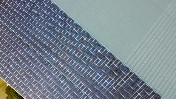 Aerial view of surface of blue photovoltaic solar panels mounted on building roof for producing