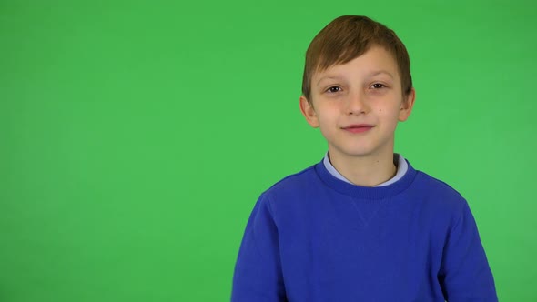 A Young Cute Boy Applauds To the Camera with a Smile - Green Screen Studio