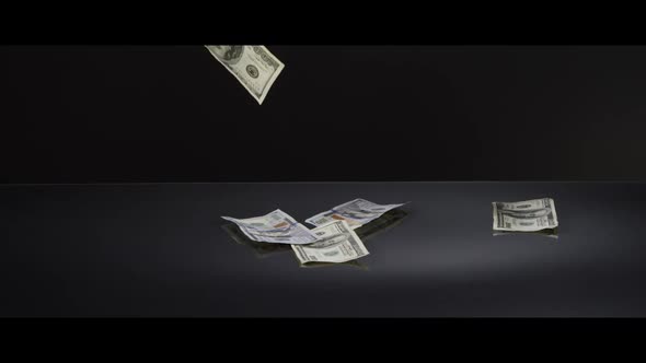 American $100 Bills Falling onto a Reflective Surface - MONEY 0044