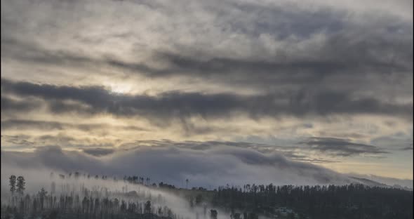 Timelapse of Evening Sun Rays Emerging Through the Cold Foggy Clouds in the Mountains