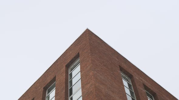 Bottom View of Brick Top Corner of Modern Building in Snowy Weather It is Snowing