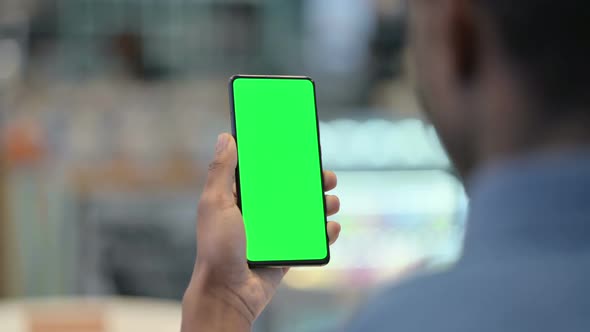 African Man Using Smartphone with Green Chroma Key Screen