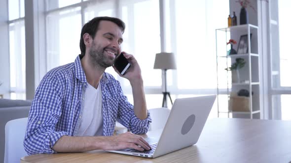 Negotiation Casual Beard Man Talking on Phone At Work to Discuss Plan