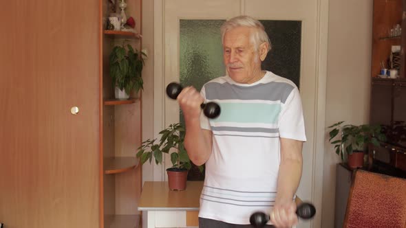 Senior Elderly Caucasian Man Doing Weight Lifting Dumbbell Exercising at Home