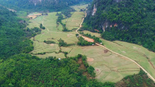 Aerial: flying over scenic cliffs rock pinnacles tropical jungle rice paddies