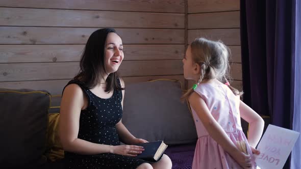 Little Girl Greeting Mom with Mothers Day Indoors