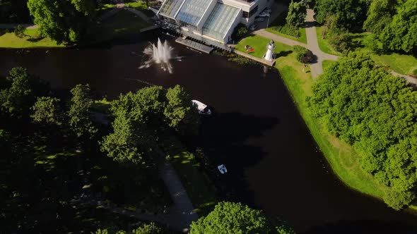 Aerial Footage of a Small Ship Going Down the Daugava River in Riga Latvia