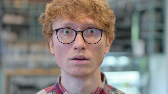 Close Up of Young Redhead Man Feeling Shocked, Surprised 