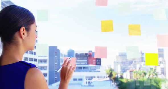 Woman taking notes on office window