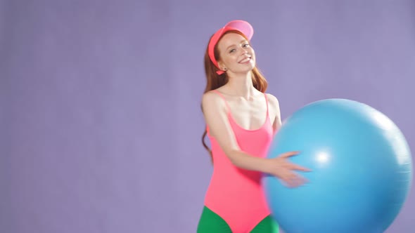 Sporty Cute Ginger Girl Making Exercises with Blue Fitness Ball, Making Warming Up Workout