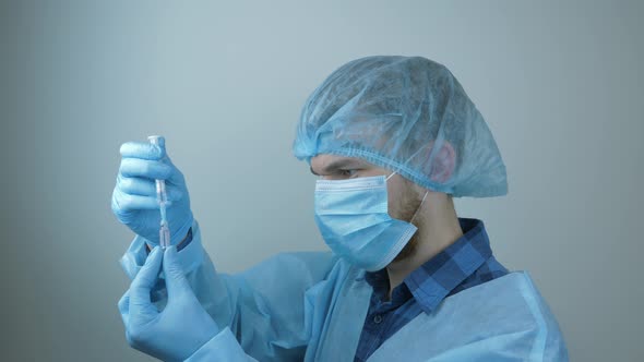 Male doctor filling syringe with drugs for injection. Science and healthcare concept