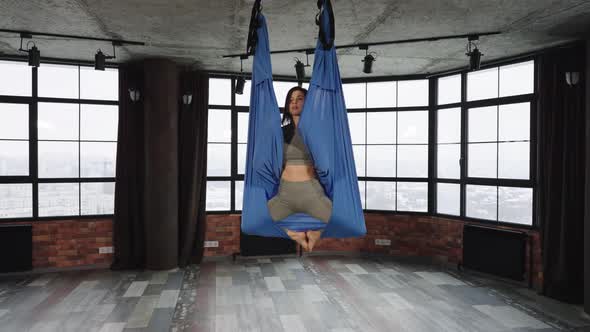 Fit Woman Wrapping in Hammock in Fly Yoga Class