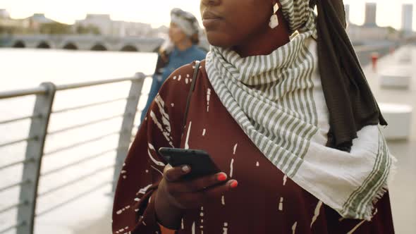 Black Woman Using Phone on Walk