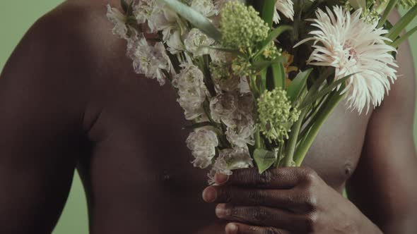 Unrecognizable Shirtless Man With Flowers