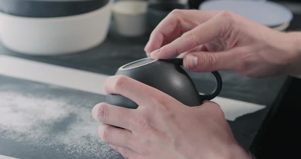 Slow Motion Man Hands Polishing Bottom of Black Ceramic Cup