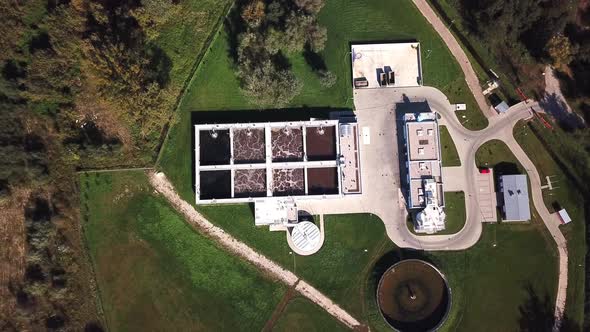Aerial top down view flying over wastewater treatment plant also known as sewage treatment plant or