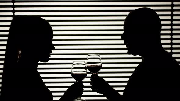 Man and Woman Drinking Wine on White Striped Background