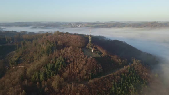 Observation tower with transmission mast sitting on the edge of a steep hill in Morsbach, Germany du