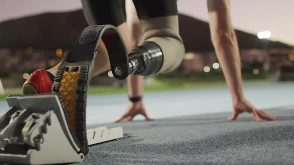 Low section of caucasian disabled male athlete with running blade getting ready to start a run