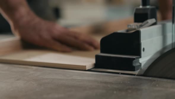 Saws Furniture Details with a Circular Saw. Close Up View of Man Wooden Production Factory Furniture