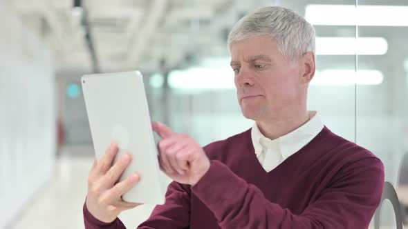 Middle Aged Man Using Digital Tablet