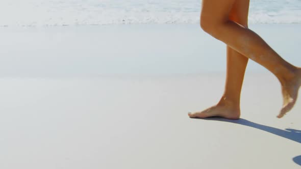 Low section of woman walking at beach on a sunny day 4k