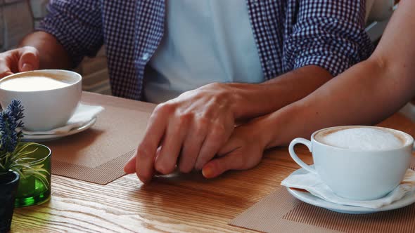 Mid section of couple holding hands