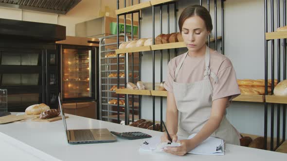 Woman Working behind Counter in Bakery