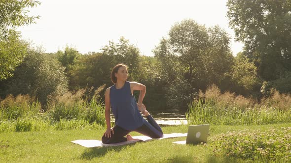 Woman practicing yoga at sunrise in park