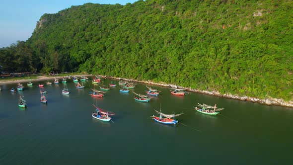 Many fishing boats on the coast beside the mountains, beautiful sea area in Thailand.